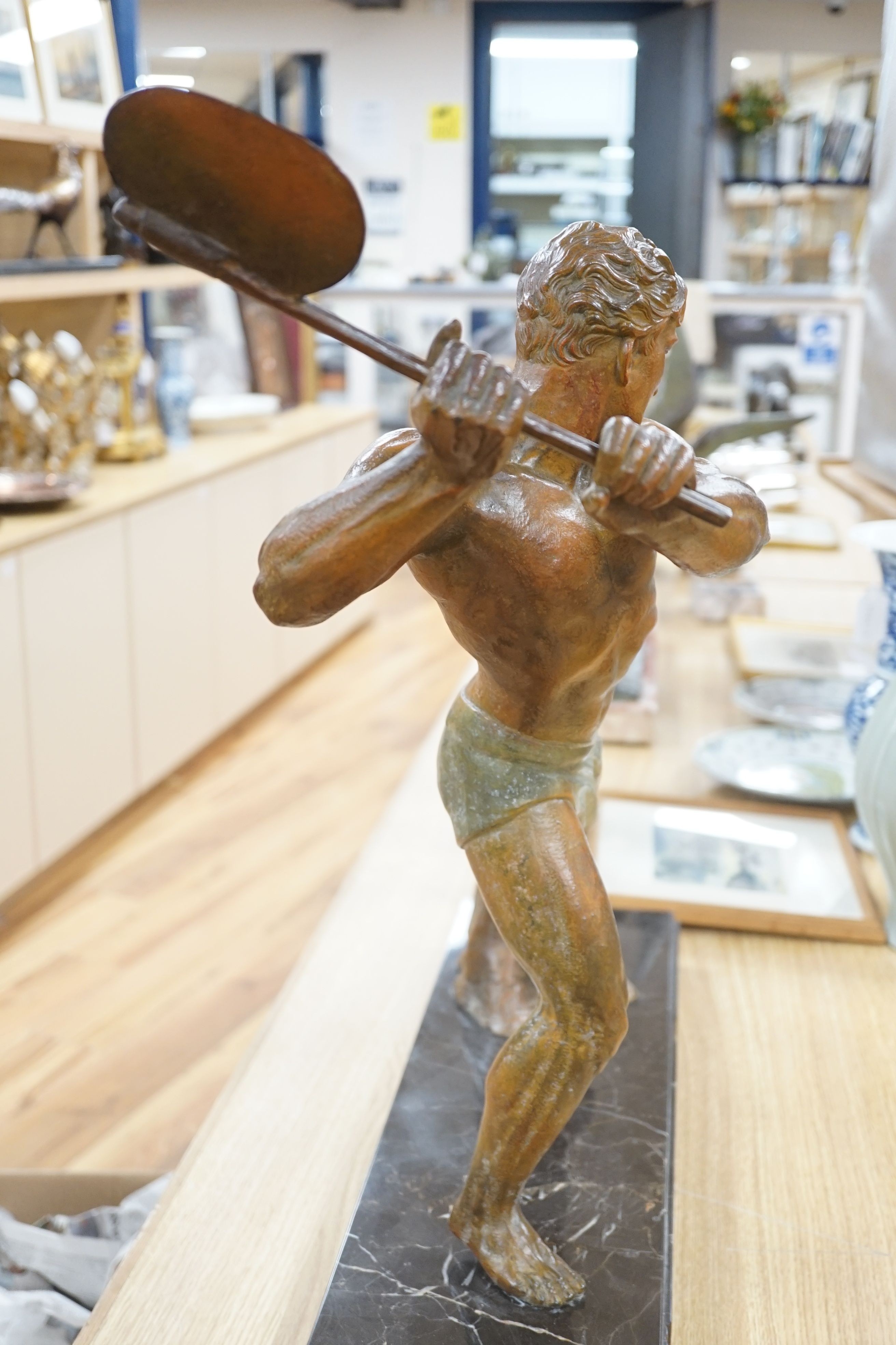 An Art Deco patinated spelter figure of a woodcutter, signed G Hervore, 75cm long